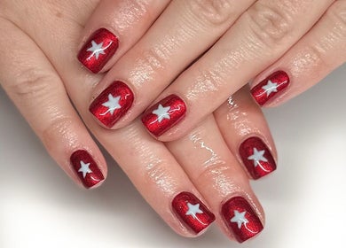 Beautiful red nails with white stars at Nails by Hannah Morant, Falmouth, England, GB.