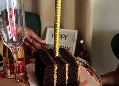 Festive birthday setup at Luxidermis Organix, Portmore, St. Catherine Parish, JM, with cake and a champagne flute.