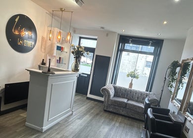 Interior of Gem Hair Design in Greenmount, England, featuring elegant seating and decor.