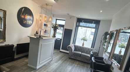 Interior of Gem Hair Design in Greenmount, England, featuring elegant seating and decor.