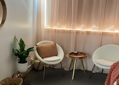 Cozy seating area at Lomi Massage Geelong in Newtown, Victoria, AU featuring chic chairs and soft lighting.