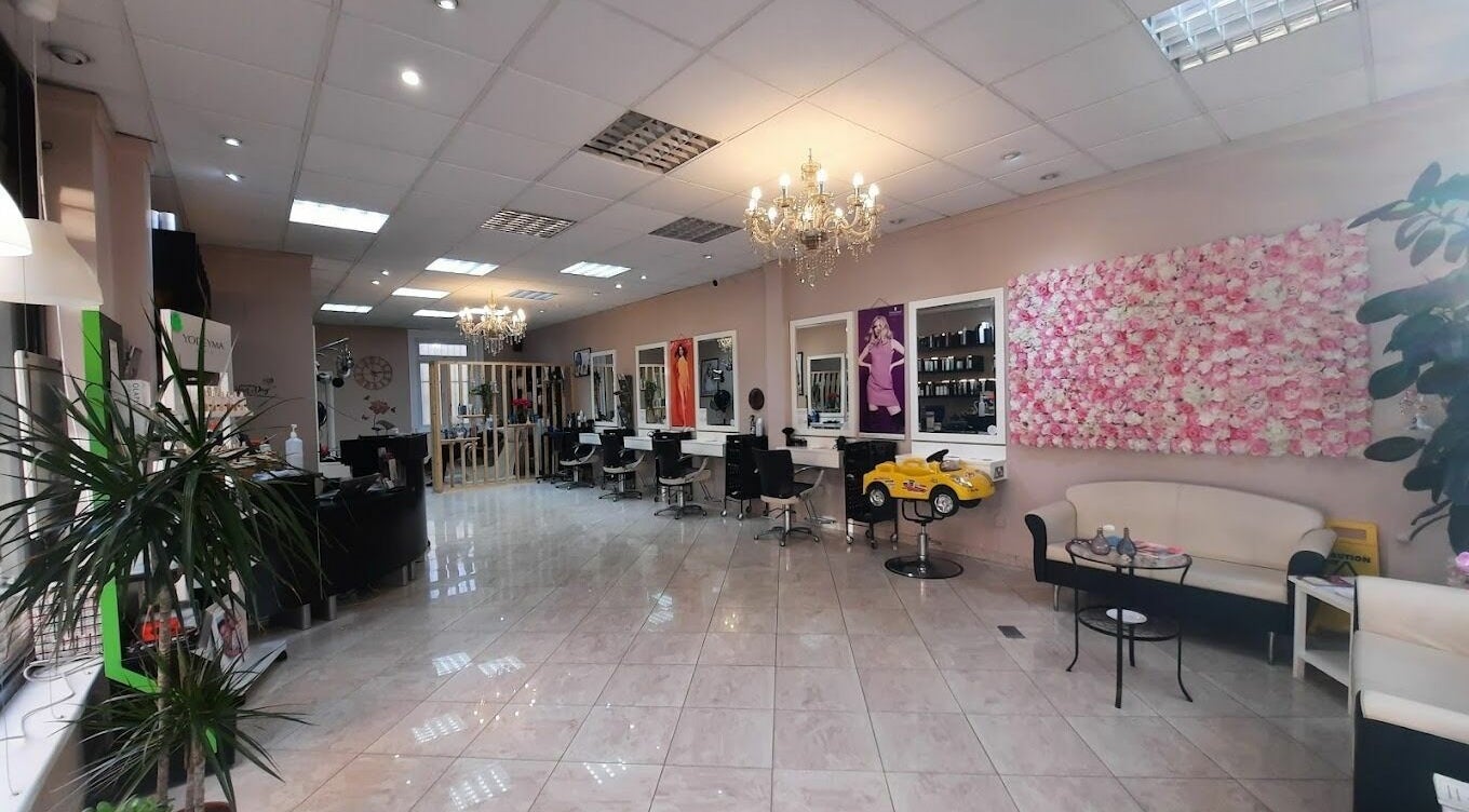 Spacious interior of Niketa Hair Lounge in London, England, GB, featuring stylish chairs and floral decor.