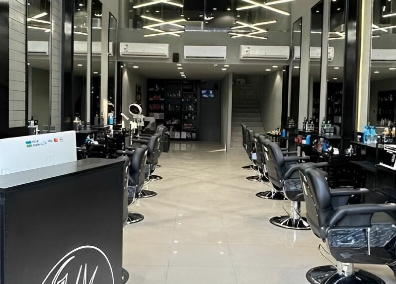 Modern salon interior of 1/2 Cuts Salon صالون هاف كت | Al Aziziyah in Riyadh, Riyadh Province, SA with rows of styling chairs.