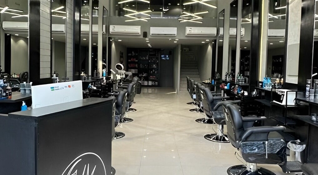 Modern salon interior of 1/2 Cuts Salon صالون هاف كت | Al Aziziyah in Riyadh, Riyadh Province, SA with rows of styling chairs.