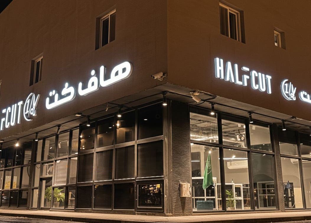 Exterior of 1/2 Cuts Salon صالون هاف كت | Al Narjis, illuminated at night in Riyadh, Riyadh Province, SA.