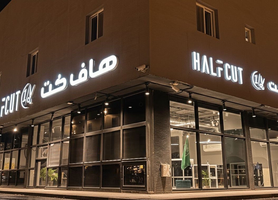 Exterior of 1/2 Cuts Salon صالون هاف كت | Al Narjis, illuminated at night in Riyadh, Riyadh Province, SA.