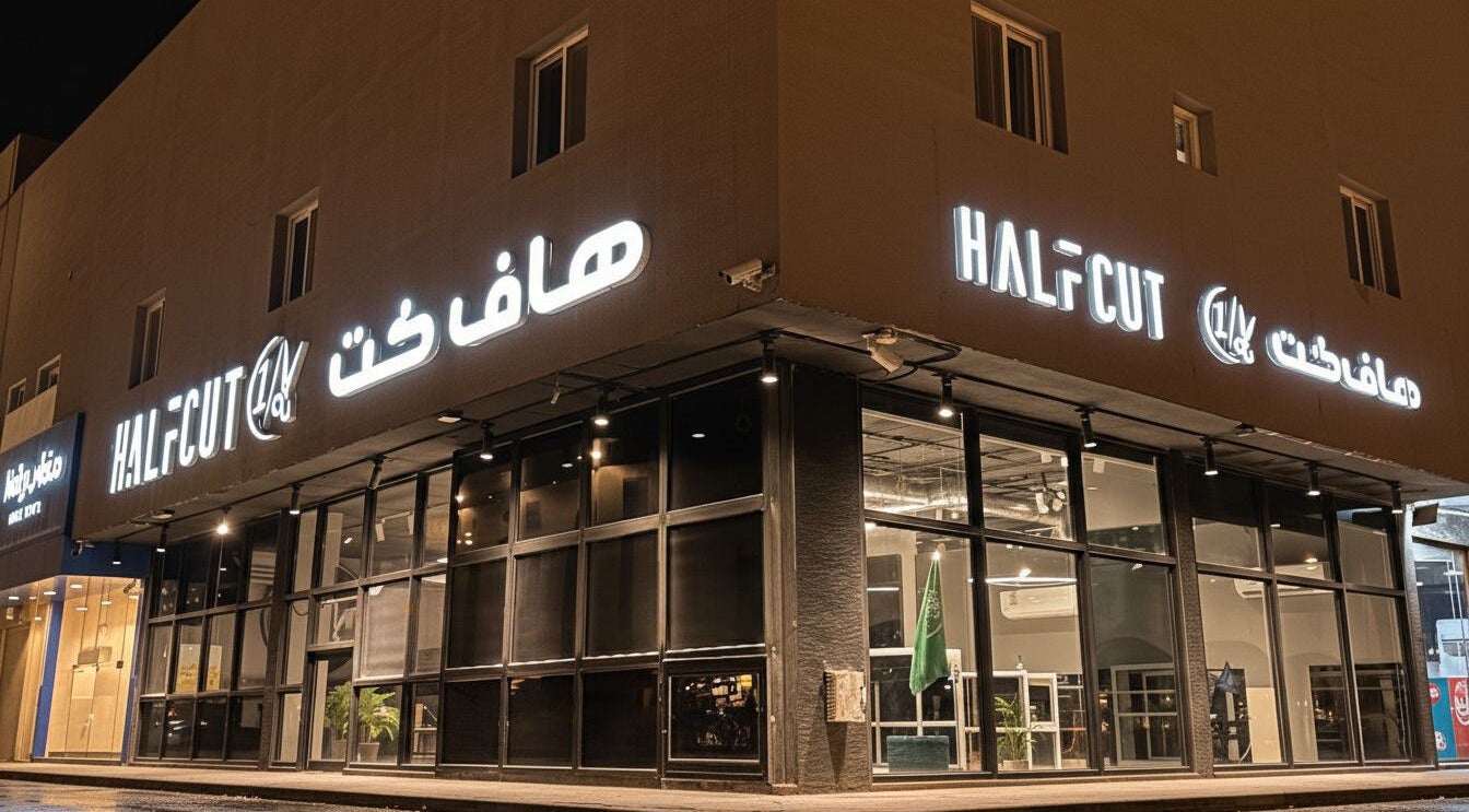 Exterior of 1/2 Cuts Salon صالون هاف كت | Al Narjis, illuminated at night in Riyadh, Riyadh Province, SA.