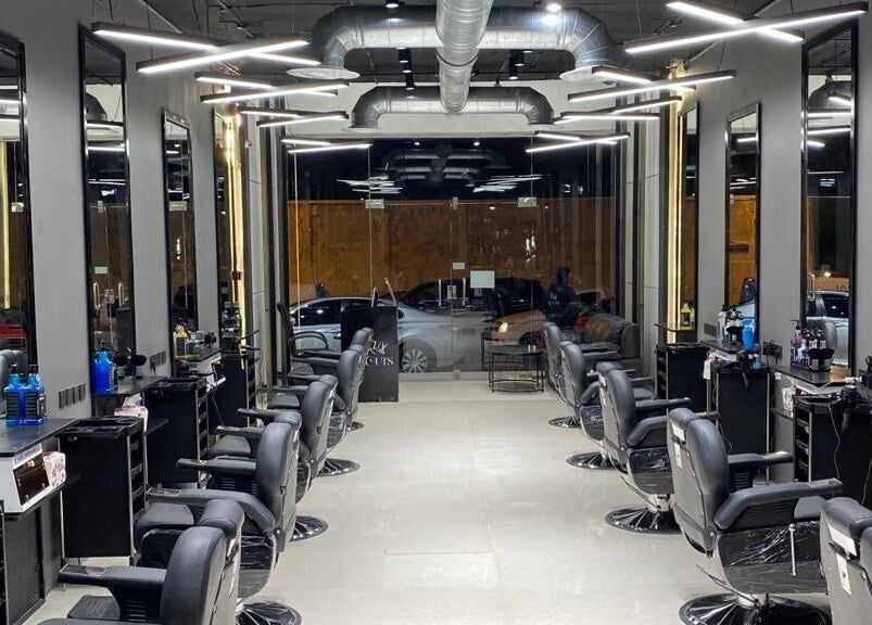 Modern interior of 1/2 Cuts Salon صالون هاف كت | Al Shifa in Riyadh, Riyadh Province, SA with stylish chairs and mirrors.