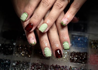 Elegant nail art with green accents at Nails by Lauren, Live Oak, Florida, US.