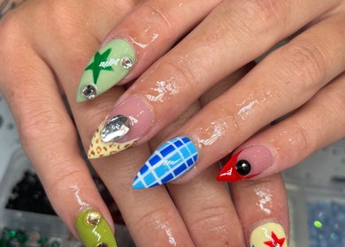 Colorful nail art at Nails by Lauren, Live Oak, Florida, US showing intricate designs and gems.