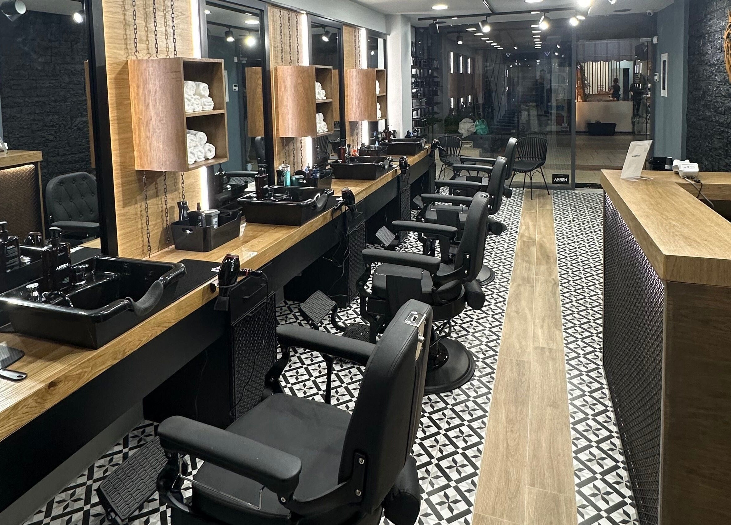 Εσωτερικό του King's Barbershop Thermi στη Θέρμη, GR, με σύγχρονη διακόσμηση και καρέκλες αναμονής.