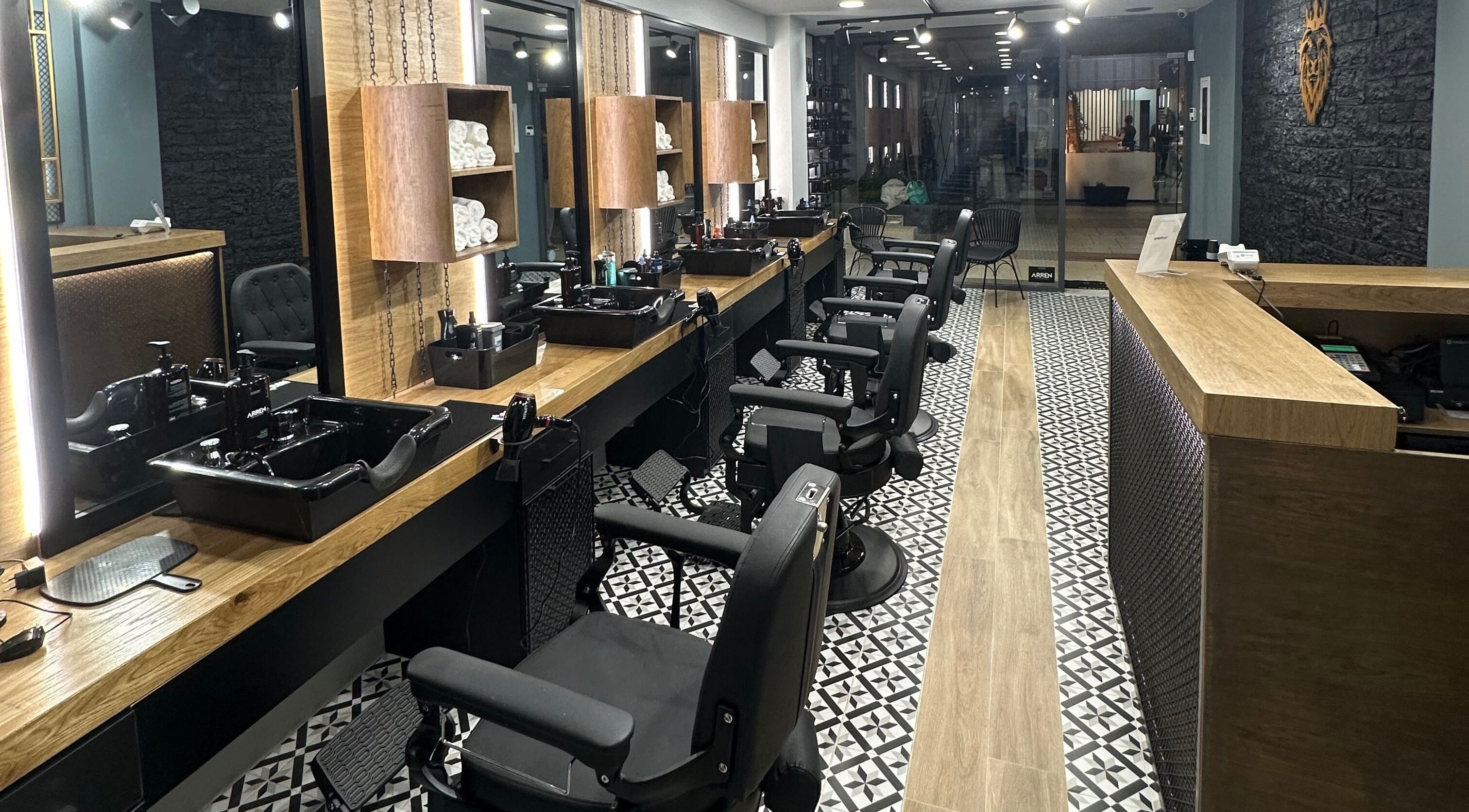 Εσωτερικό του King's Barbershop Thermi στη Θέρμη, GR, με σύγχρονη διακόσμηση και καρέκλες αναμονής.