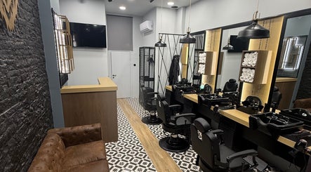 Κομψή εσωτερική διακόσμηση στο King’s Barbershop Kalamaria, Καλαμαριά, GR, με μοντέρνες καρέκλες και καθρέφτες.