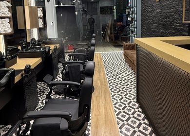 Εσωτερικό του King’s Barbershop Kalamaria, Καλαμαριά, GR, με μοντέρνα καρέκλες και φινετσάτο ντεκόρ.