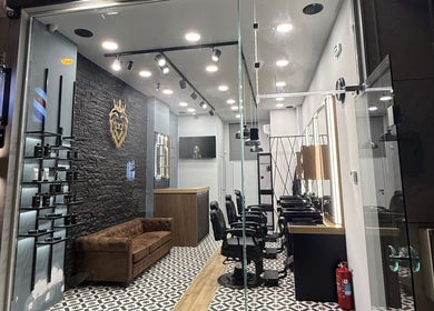 Εσωτερικό του King's Barbershop Kalamaria στην Καλαμαριά, GR με μοντέρνα σχεδίαση και αναπαυτικό καναπέ.