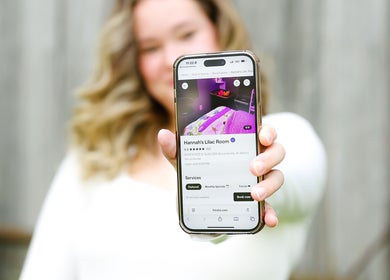 Person holds phone showing Hannah’s Lilac Room listing in Mccordsville, Indiana, US.