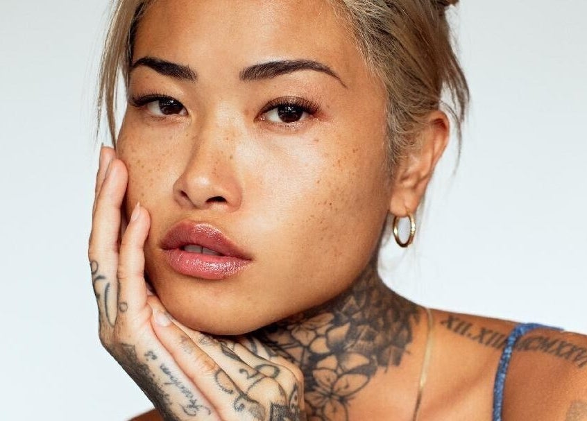 Showcasing graceful beauty at Dejavu Lashes, London, England, GB with distinct tattoos.