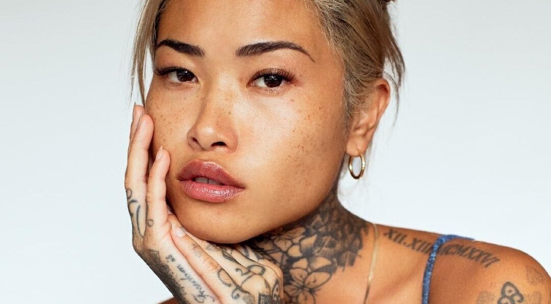 Showcasing graceful beauty at Dejavu Lashes, London, England, GB with distinct tattoos.