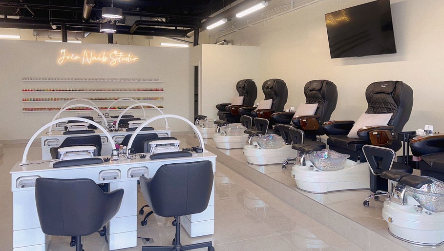 Interior of Joir Nails Studio Inc. in Bedford, Nova Scotia, CA showcasing modern nail stations and pedicure chairs.