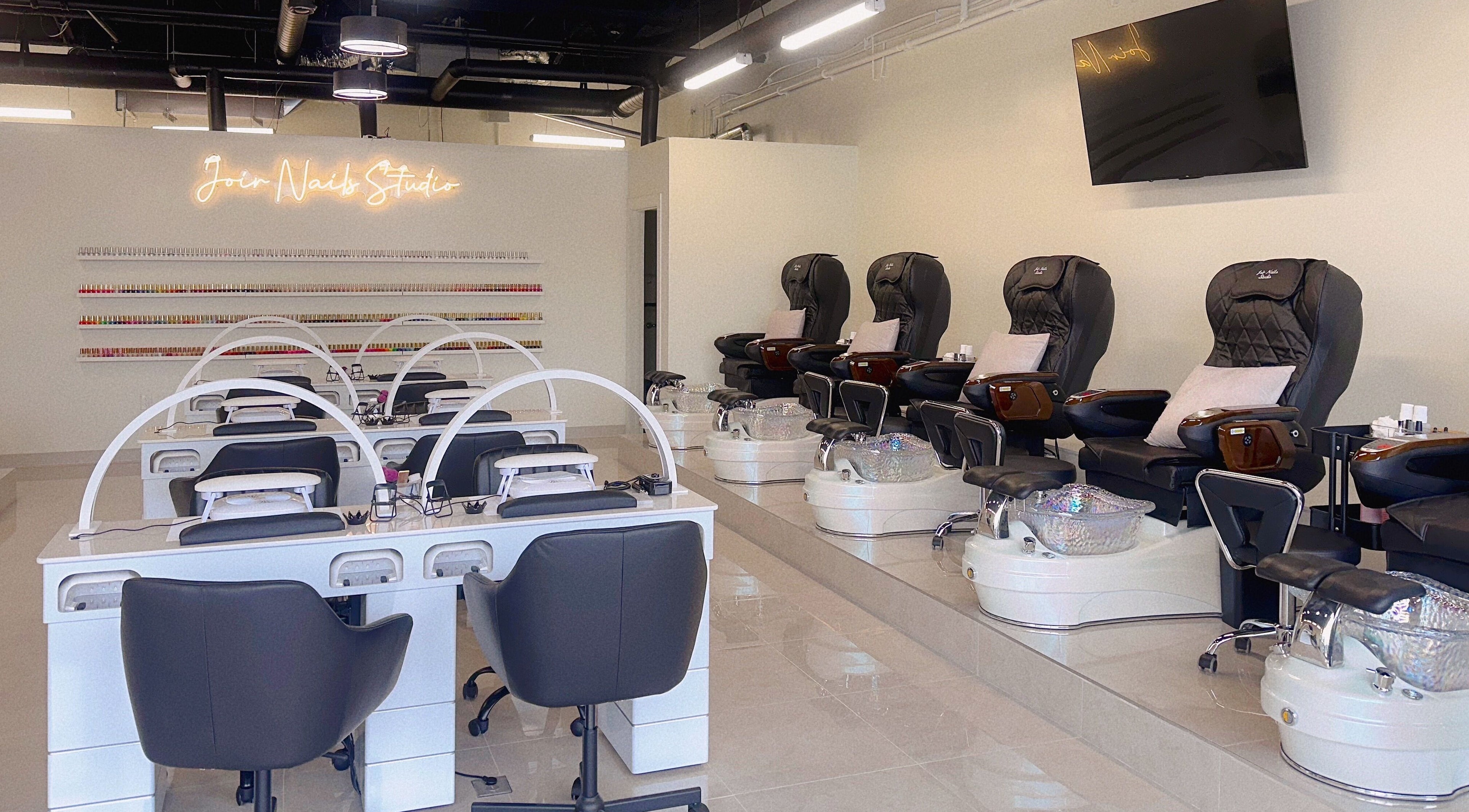 Interior of Joir Nails Studio Inc. in Bedford, Nova Scotia, CA showcasing modern nail stations and pedicure chairs.