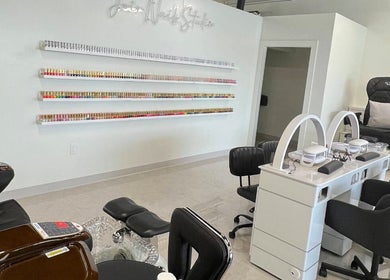 Chic interior of Joir Nails Studio Inc. in Bedford, Nova Scotia, CA showcasing sleek nail stations and polish display.