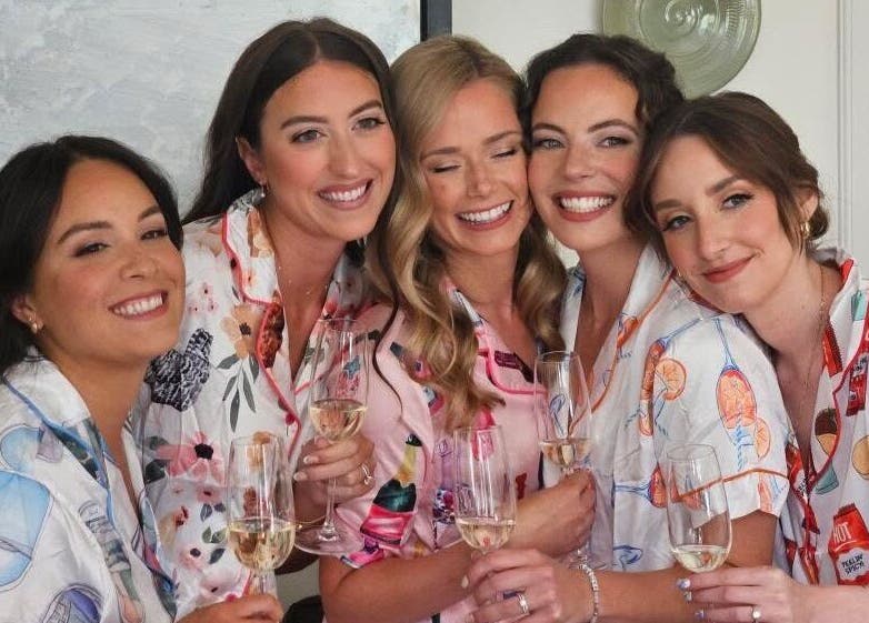 Group of smiling women in pajamas holding champagne at Glam By Shan in Newmarket, Ontario, CA.