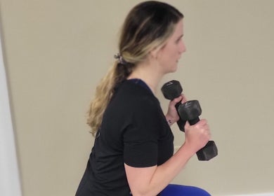 Person performing a lunge with dumbbells at Stealth Fitness, Green Bay, Wisconsin, US.
