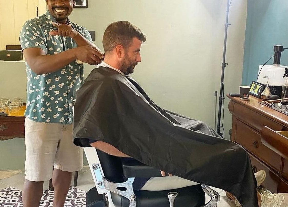 Barber giving a stylish haircut at U. The Barbershop, Willemstad, Curaçao, CW, showcasing interior and tools.