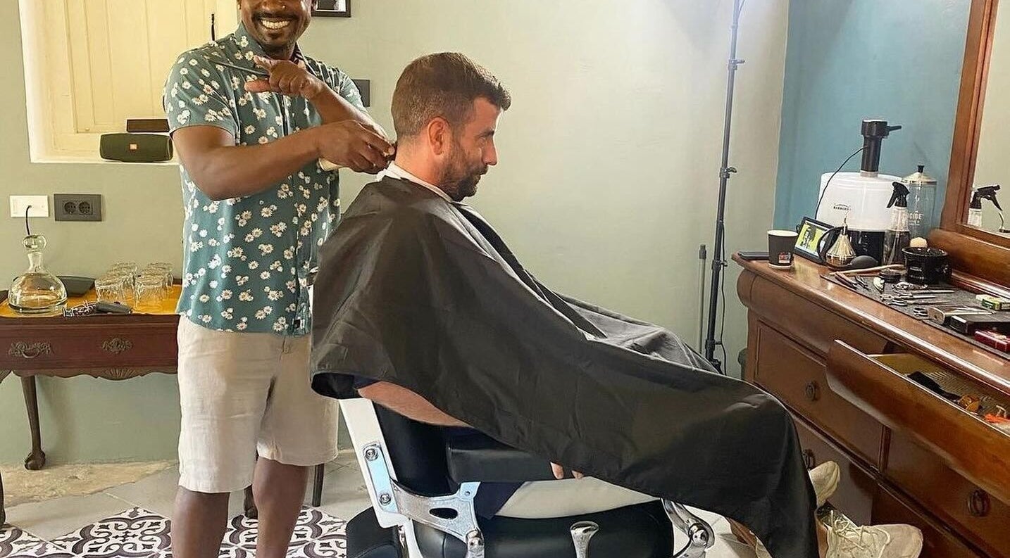 Barber giving a stylish haircut at U. The Barbershop, Willemstad, Curaçao, CW, showcasing interior and tools.