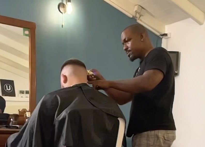 Professional barber styling at U. The Barbershop, Willemstad, Curaçao, CW. Modern interior and skilled haircut service.