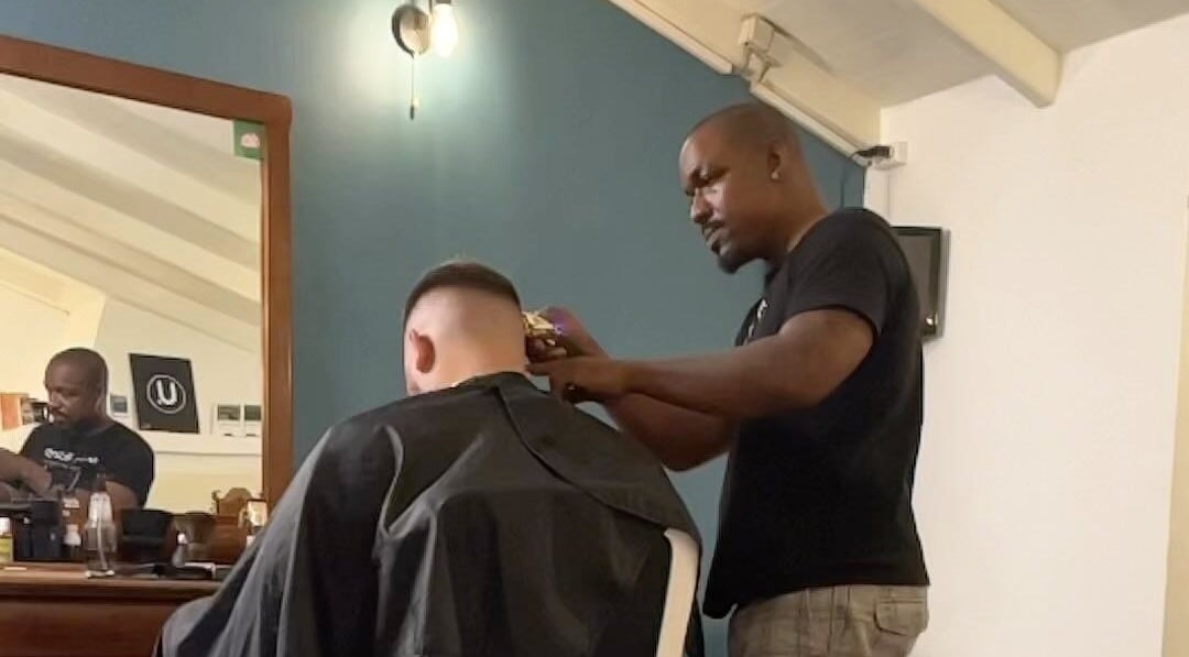 Professional barber styling at U. The Barbershop, Willemstad, Curaçao, CW. Modern interior and skilled haircut service.