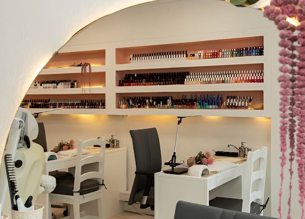 Modern nail salon area in Pure Essence Spa, Kralendijk, Bonaire, BQ with sleek chairs and colorful polish shelves.