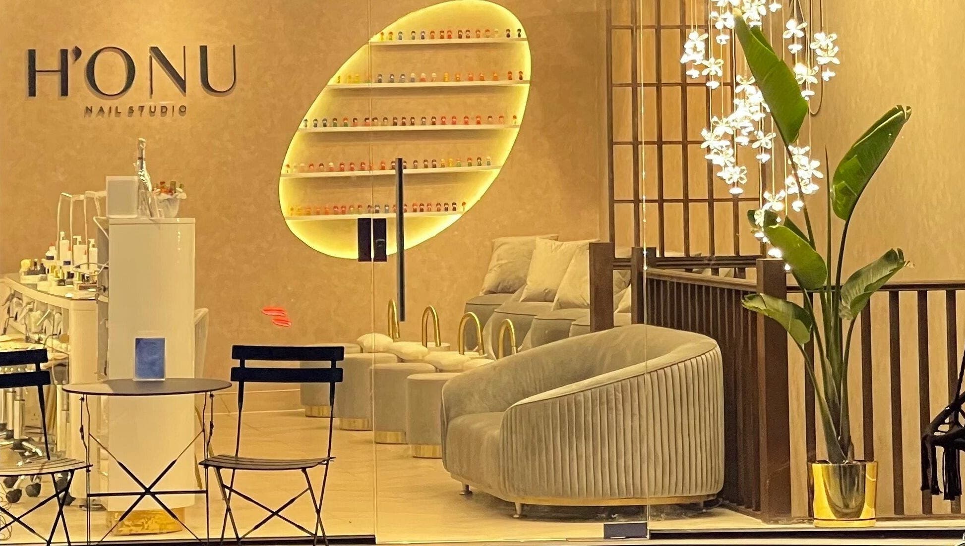 Interior of Honu Nail Studio - West Hampstead, London, England, GB. Cozy chairs, elegant decor, warm lighting.