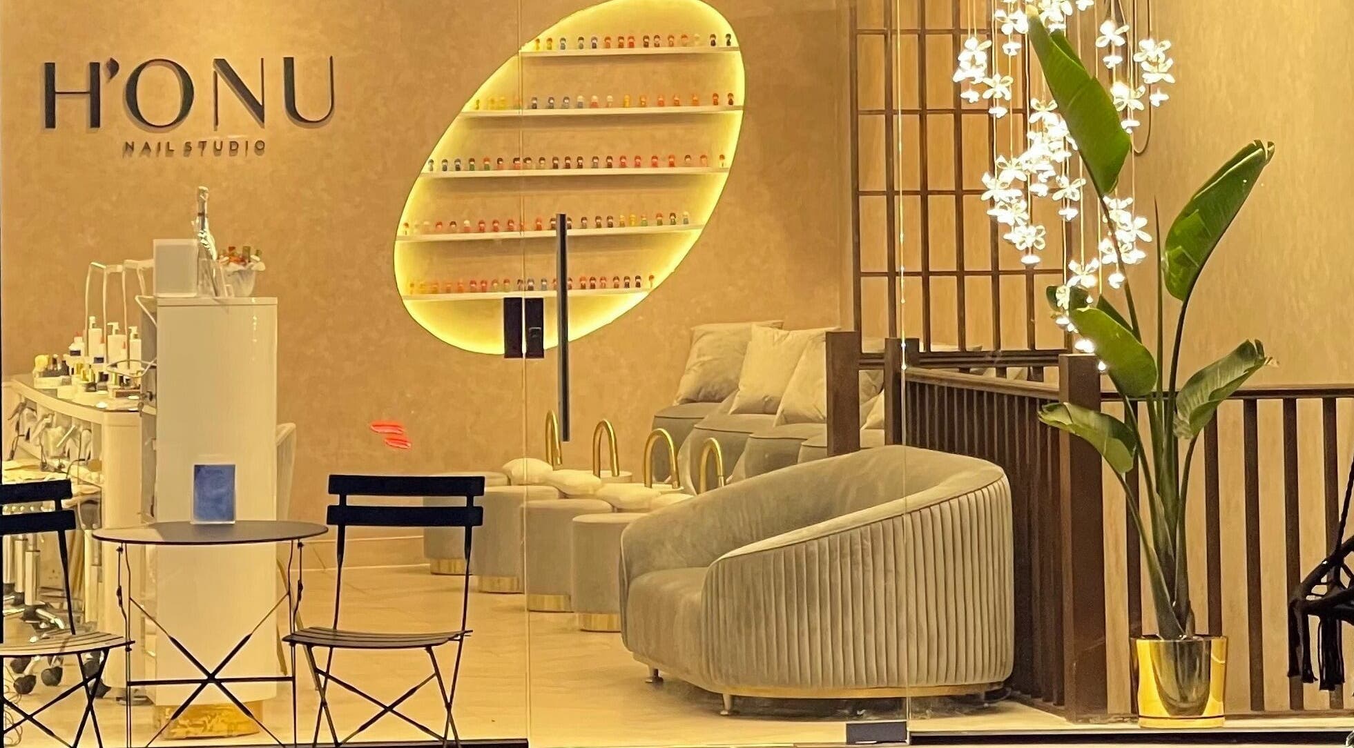 Interior of Honu Nail Studio - West Hampstead, London, England, GB. Cozy chairs, elegant decor, warm lighting.