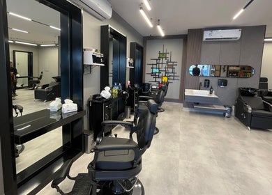 Modern interior of The Address Barber | صالون العنوان النزهة in Riyadh, with stylish chairs and mirrors.