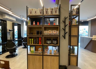 Interior of The Address Barber | صالون العنوان النزهة, featuring chairs and grooming products in Riyadh, Riyadh Province, SA.