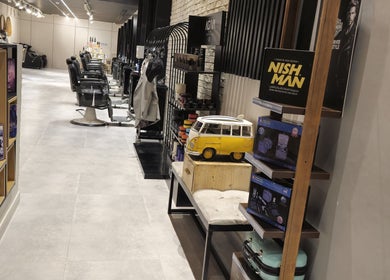 Interior of The Address Barber | صالون العنوان اشبيليا in Riyadh, featuring modern chairs and stylish decor.
