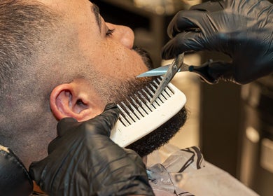 Close-up of a barber crafting a precise beard trim at The Address Barber | صالون العنوان اشبيليا, Riyadh, SA.