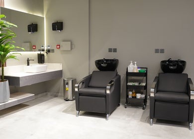 Modern interior of The Address Barber | صالون العنوان الملقا in Riyadh, SA with sleek barber chairs and washbasins.