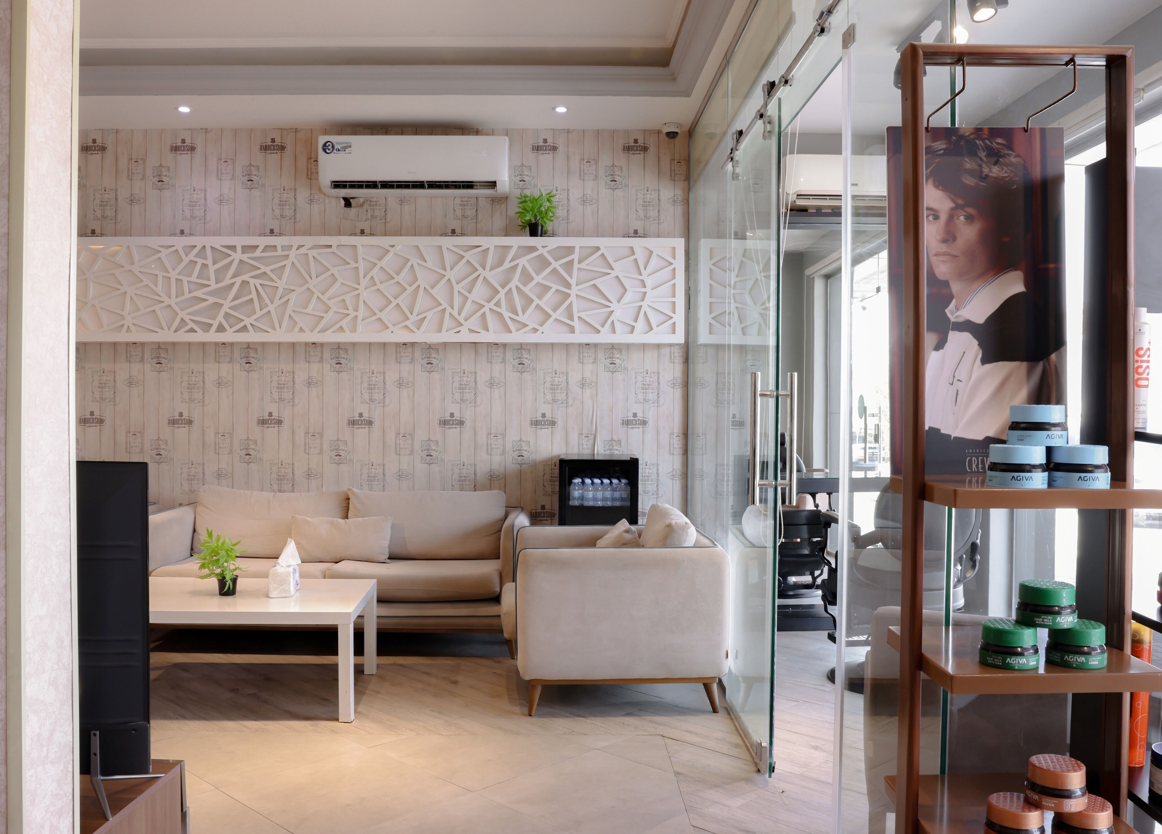 Modern waiting area at The Address Barber | صالون العنوان الروضة, Riyadh, SA, showcasing elegant seating and products.