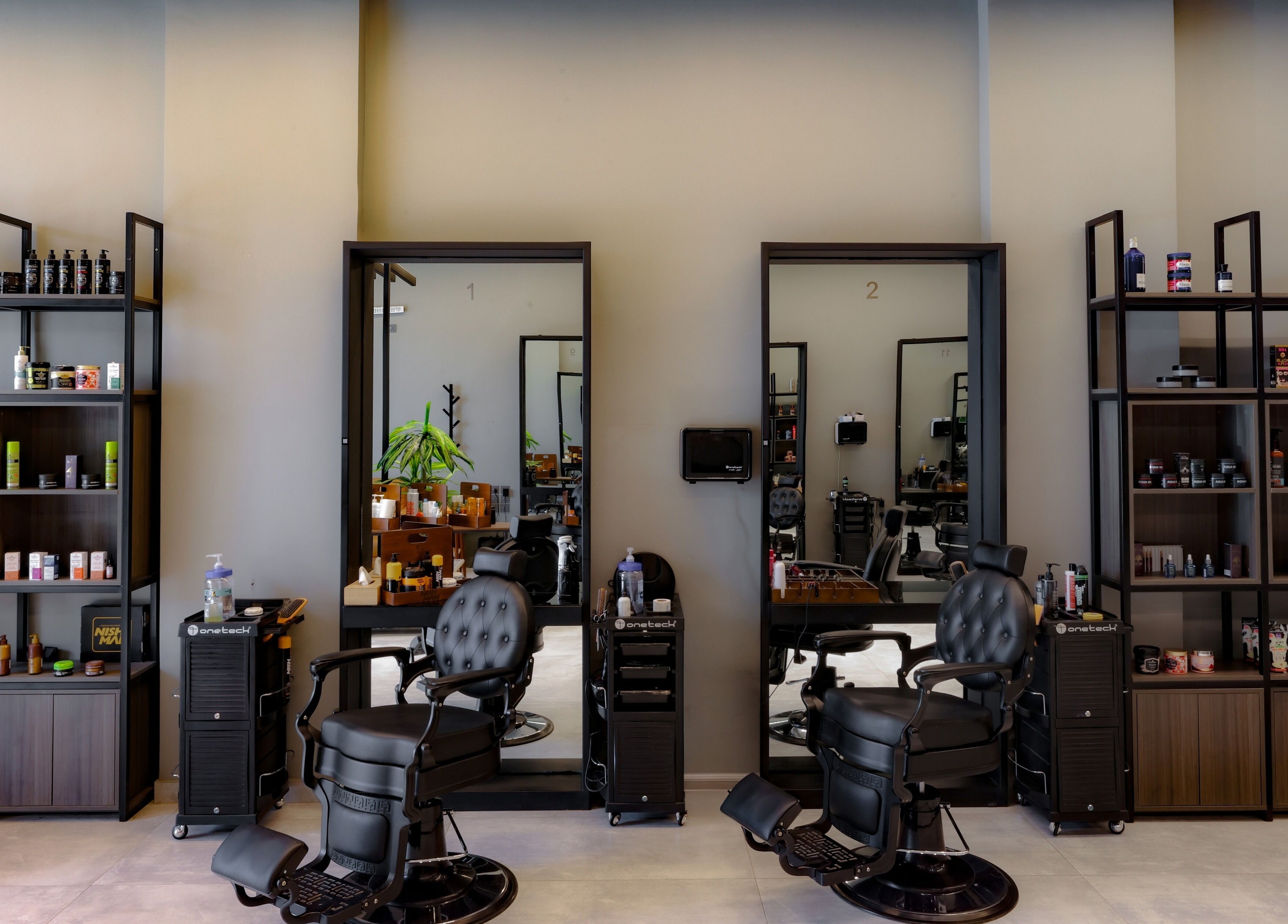 Elegant interior of The Address Barber | صالون العنوان قرطبة, Riyadh, SA with sleek chairs and shelves.