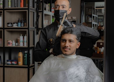 Professional barber styling hair at The Address Barber | صالون العنوان النزهة, in Riyadh, Riyadh Province, SA.