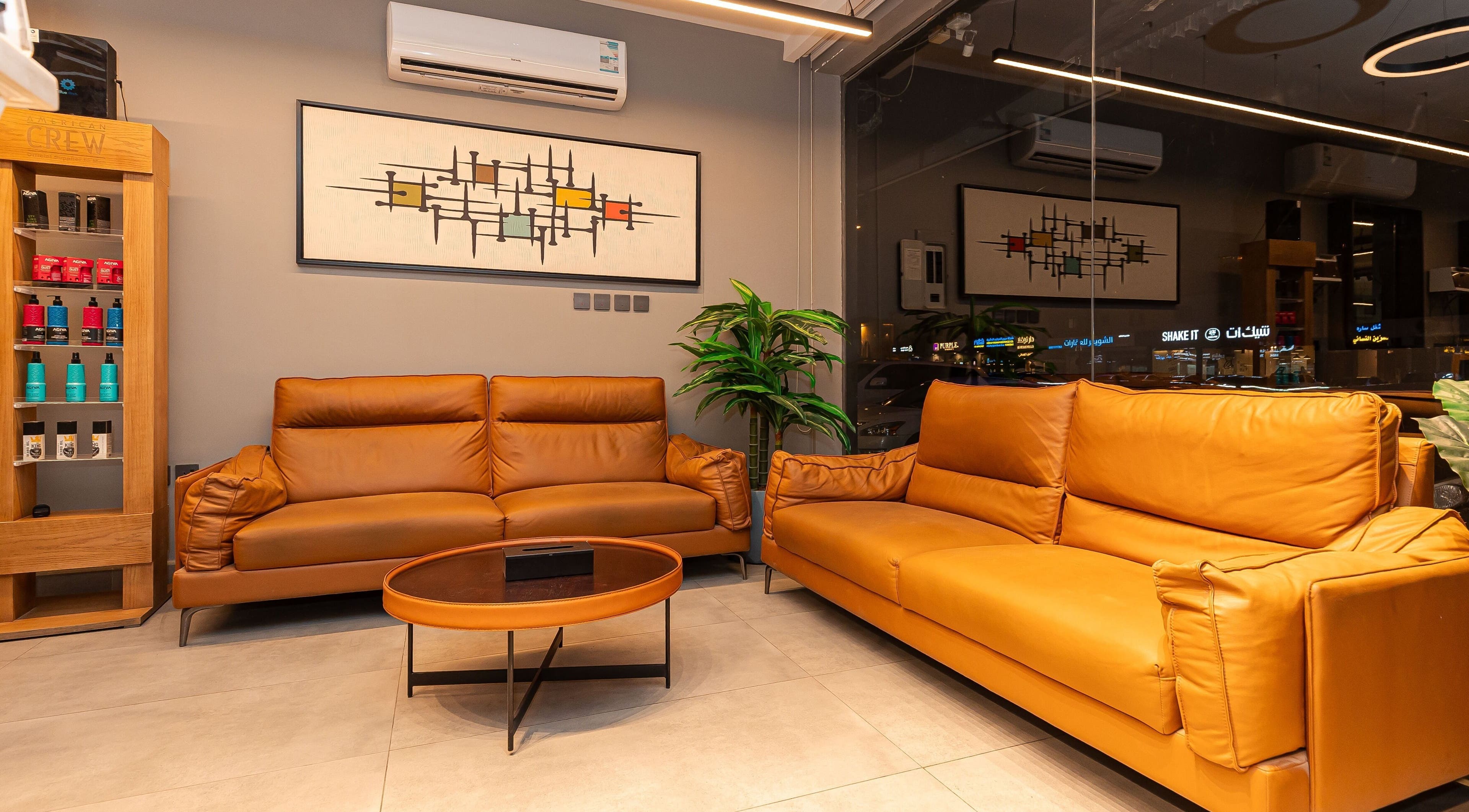 Cozy lounge area at The Address Barber | صالون العنوان الغدير in Riyadh, Riyadh Province, SA with leather sofas.
