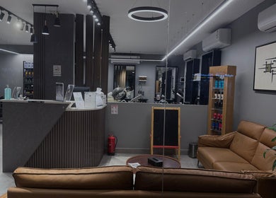 Modern interior of The Address Barber | صالون العنوان الغدير in Riyadh, showcasing sleek seating and decor.