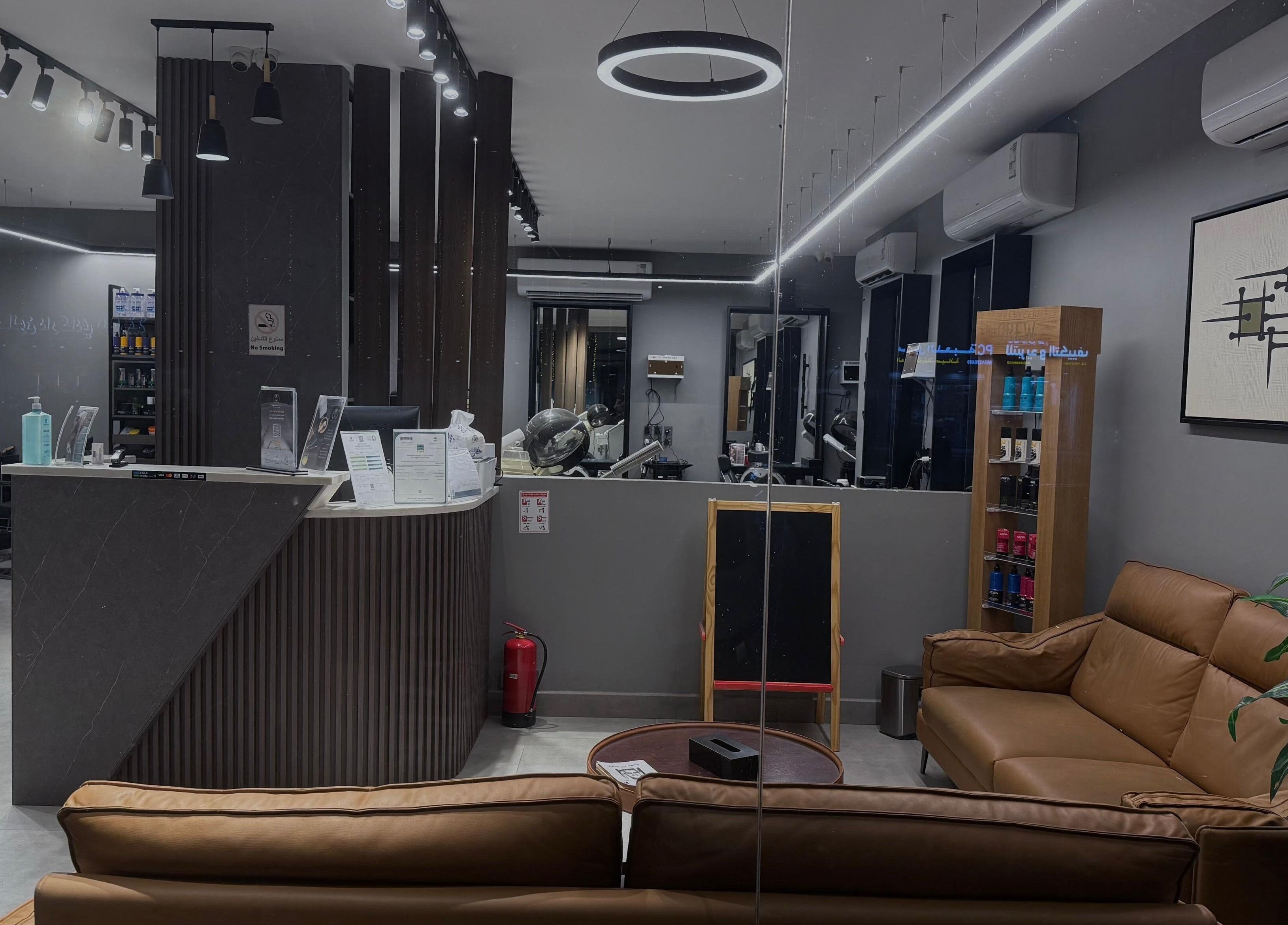 Modern interior of The Address Barber | صالون العنوان الغدير in Riyadh, showcasing sleek seating and decor.