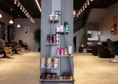 Stylish interior of The Address Barber | صالون العنوان العارض, Riyadh, with modern chairs and product display.