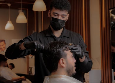 Barber styling a client's hair at The Address Barber | صالون العنوان القيروان in Riyadh, Riyadh Province, SA.