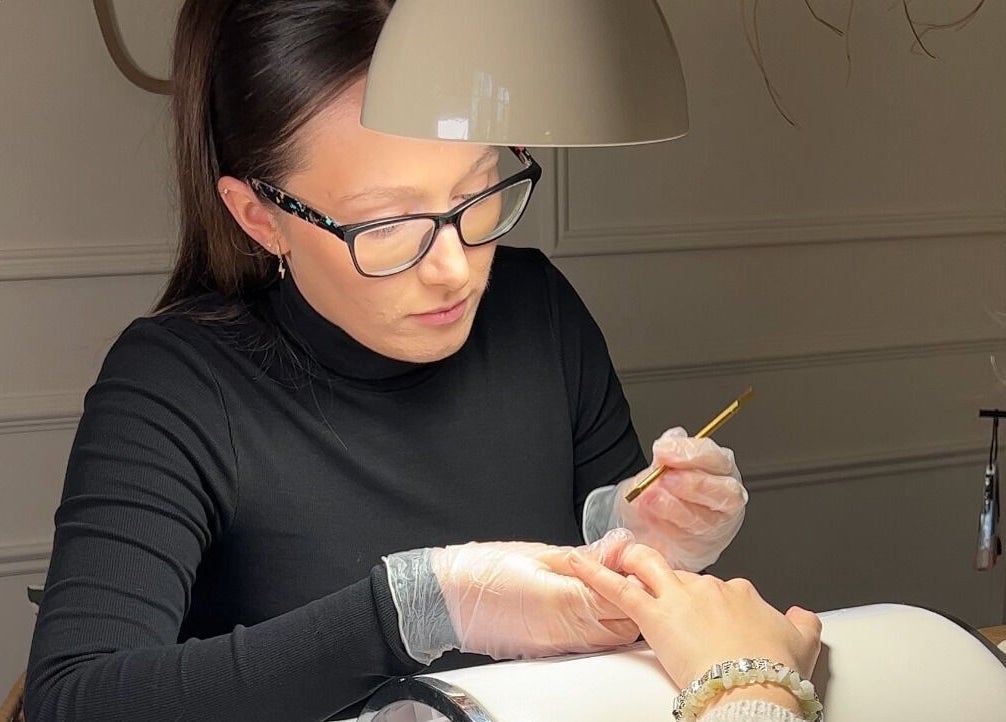 A nail artist at Ocean Bloom - Troon applying polish in Camborne, England, GB.