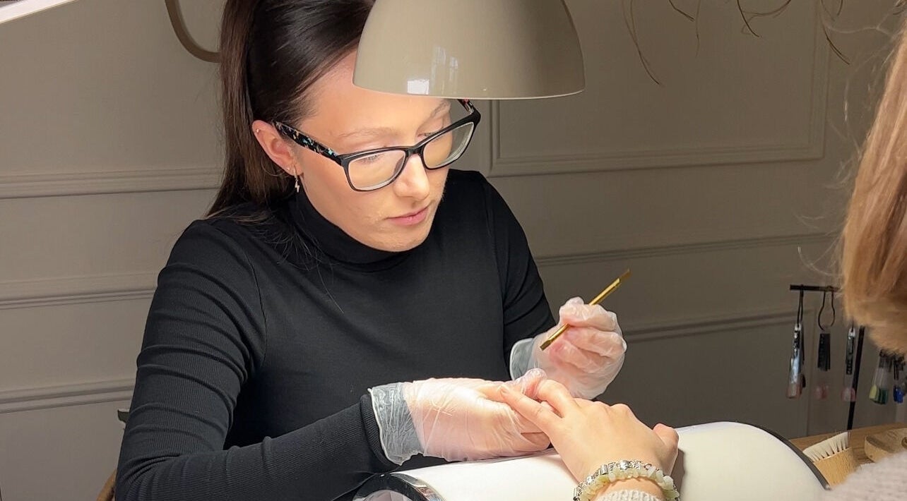 A nail artist at Ocean Bloom - Troon applying polish in Camborne, England, GB.