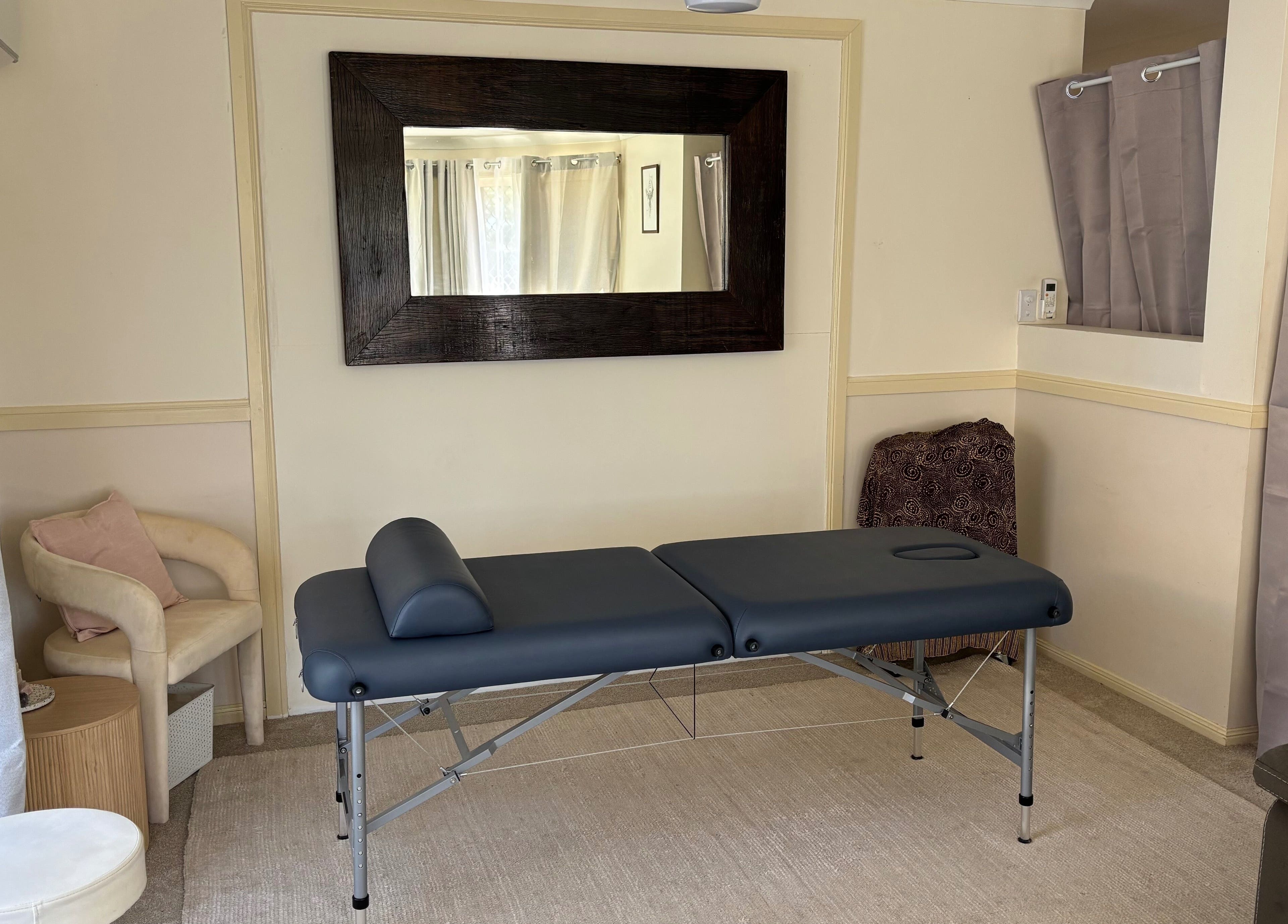 Relaxing treatment room at Muscle Recovery, Murrumba Downs, Queensland, AU with massage table and seating.